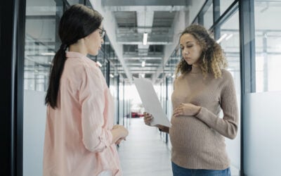 Employee reviewing FMLA paperwork, termination notice, HR emails, and calendar dates showing close timing after medical leave request.